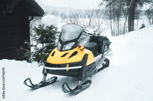 Snowmobile, empty, against the backdrop of the winter forest © Mariana