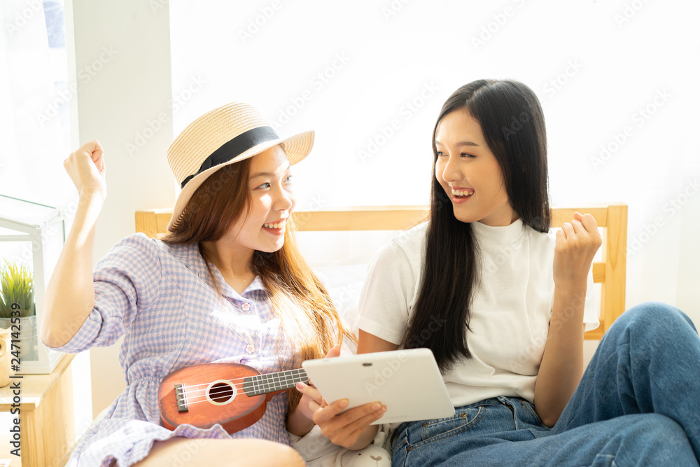 Young asian happy woman planning for travel in bed room .Check-in online for booking her flight trip.