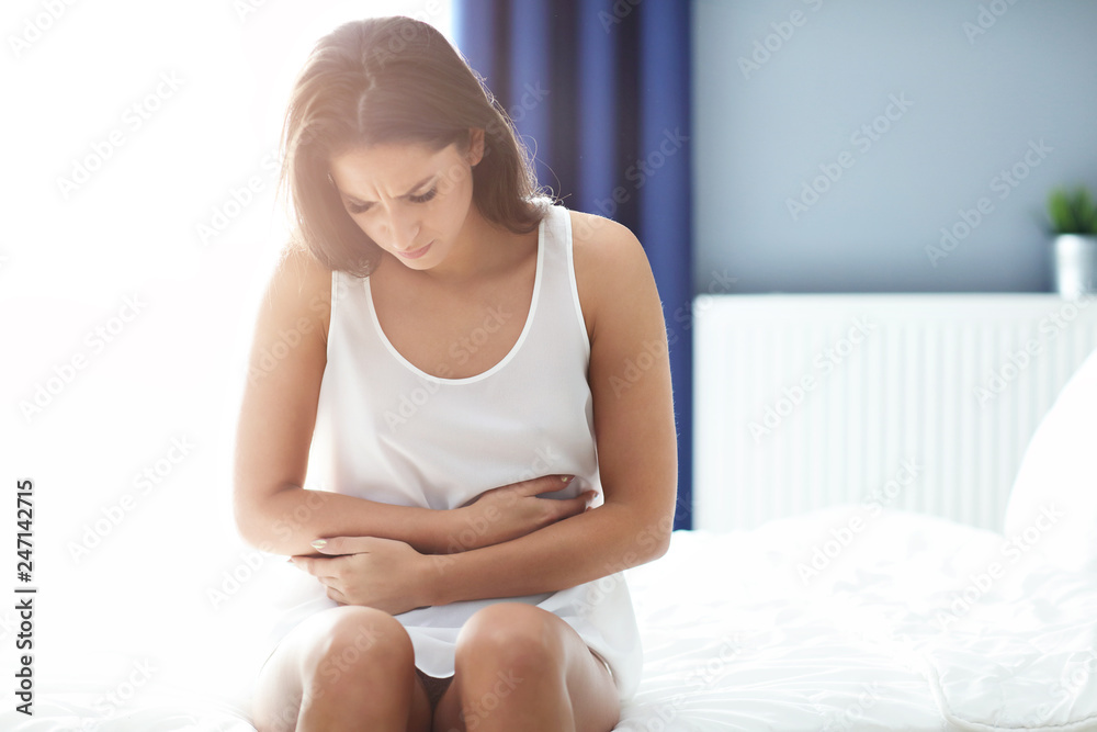 Adult woman waking up in the morning feeling sick Adult woman waking up in the morning feeling sick