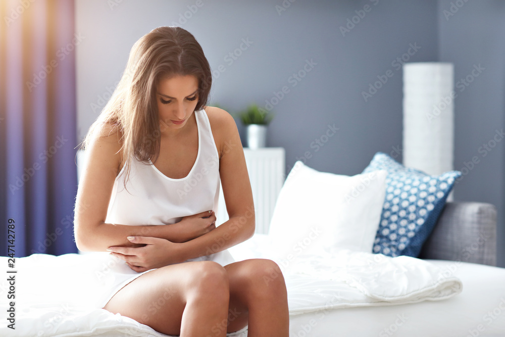 Adult woman waking up in the morning feeling sick Adult woman waking up in the morning feeling sick