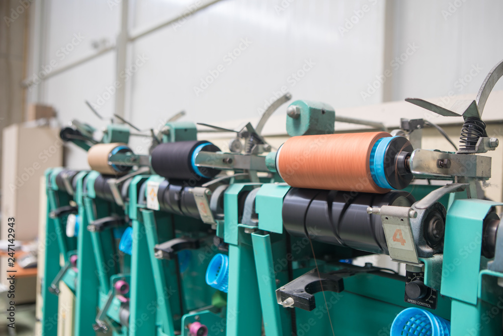 Group of bobbin thread cones on a warping machine in a textile mill. Yarn ball making in a textile factory. Textile industry - yarn spools on spinning machine in a textile factory