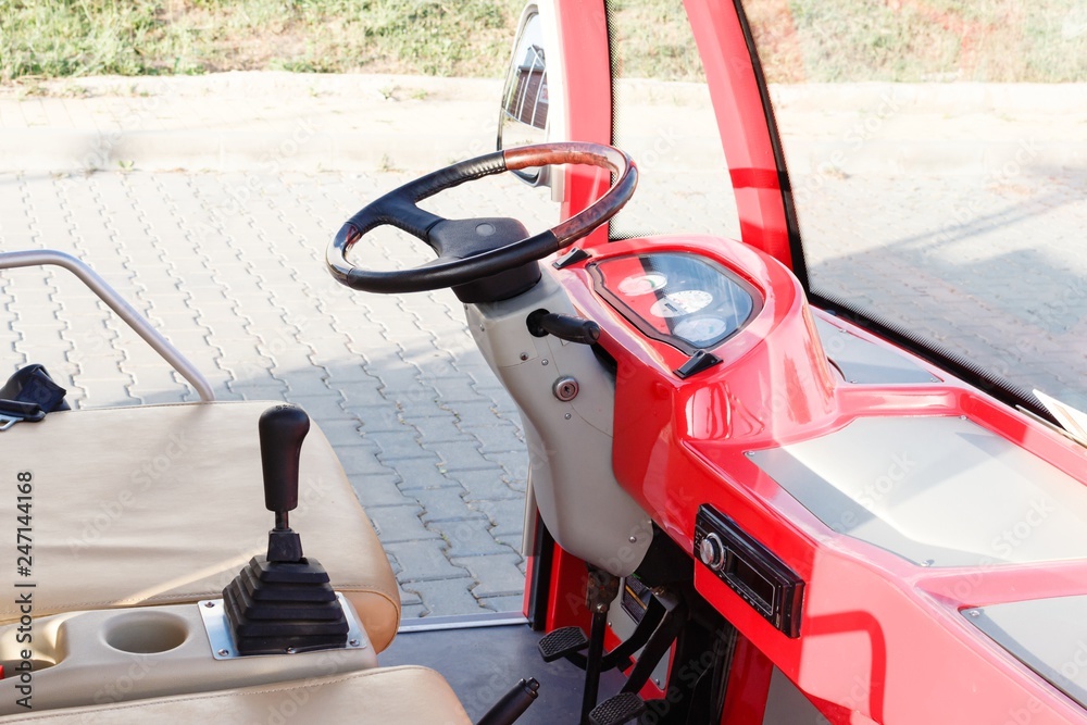 Fototapeta premium Empty cab and old model steering wheel of red colored open touristic minibus in Byala, Bulgaria.