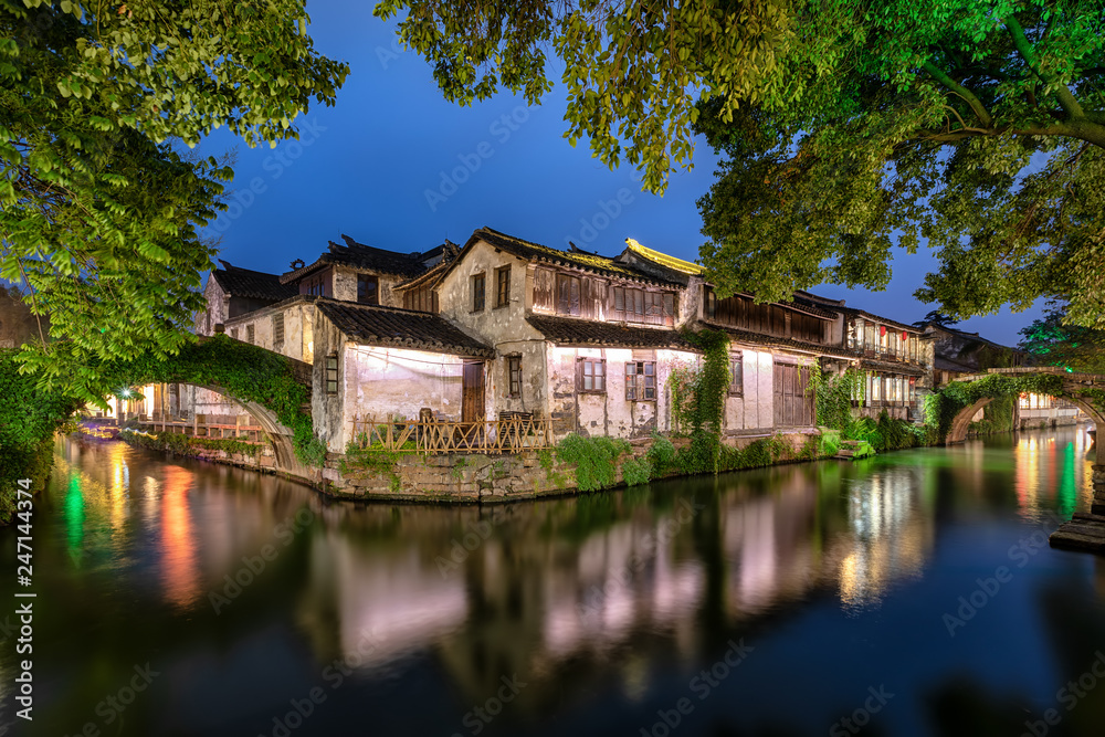 Die Kanäle, Brücken und alte Gebäude der antiken Wasserstadt Zhouzhuang bei Shanghai in China am Abend