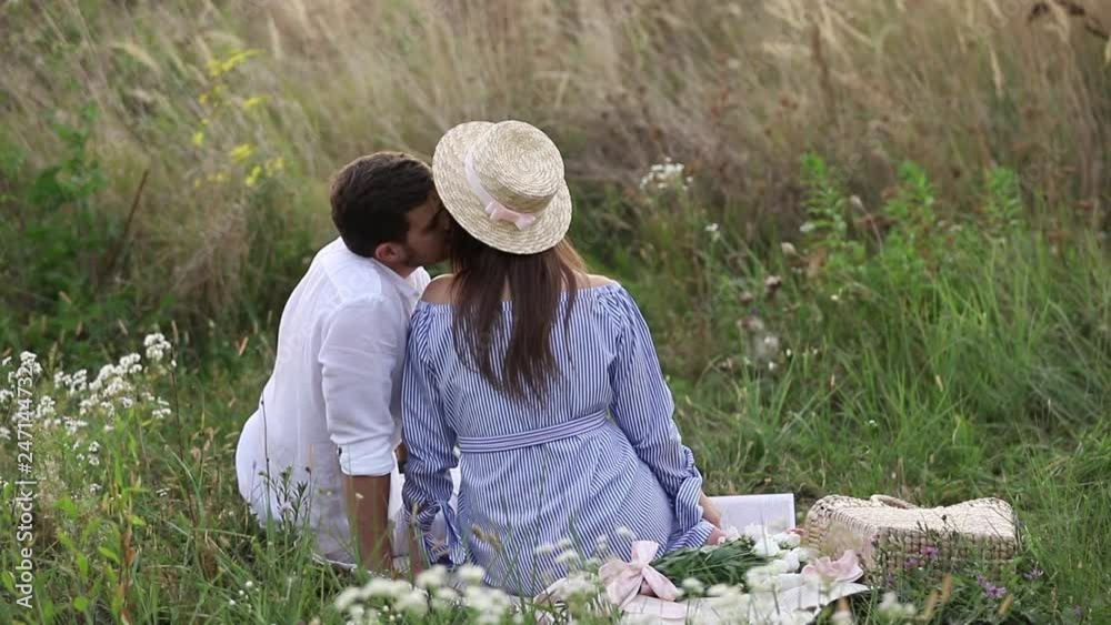 Future mom and dad sits in field. Pregnant woman with her husband put their hands on belly