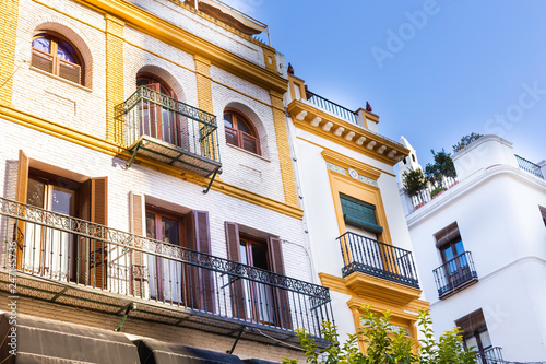 Traditional facades of houses with twisted wrought and carved balconies of the city of Seville, Andalusia, Spain. © Ирина Селина