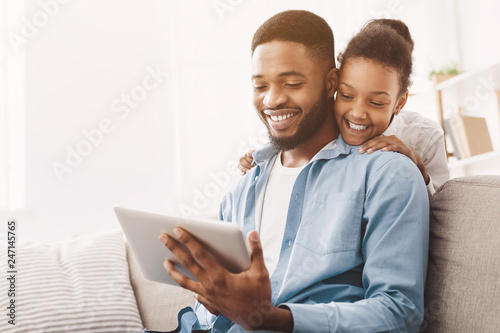 Father and daughter having video call on tablet