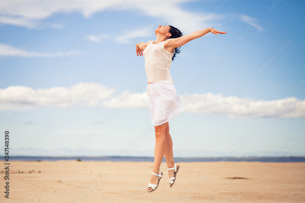 slender brunette in white clothes jumping in the sandy desert slender brunette in white clothes jumping in the sandy desert