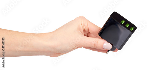 Hand with black USB wall chrger plug, three ports.