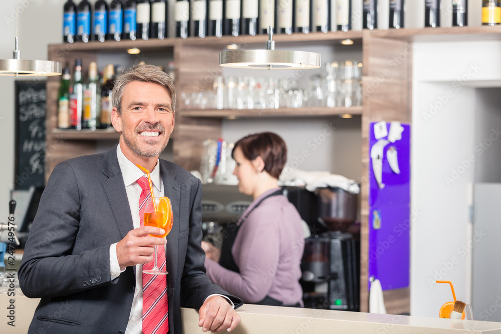 Happy man holding orange cocktail at restaurant Happy man holding orange cocktail at restaurant