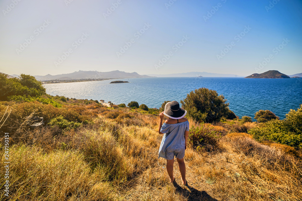 Beautiful woman in beach hat enjoying sea view with blue sky at sunny day in Bodrum, Turkey. Vacation Outdoors Seascape Summer Travel Concept