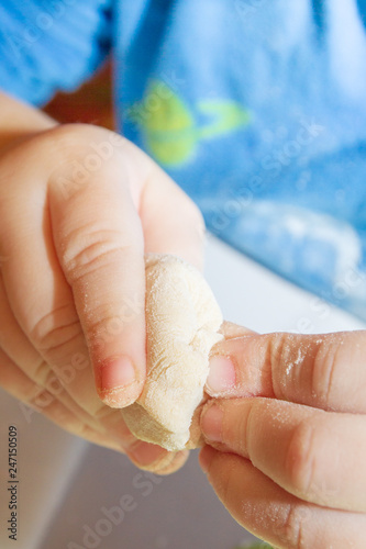 Small boy sculpts a homemade ravioli at home