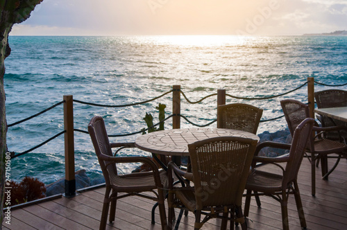table and chairs in a cafe on the shore of the sea in the rays of the sunset