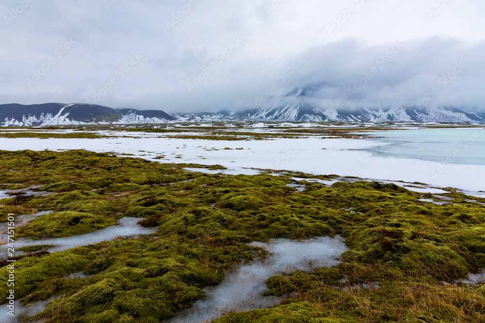 Isländische Winterlandschaft mit Bergen, See und Moos Isländische Winterlandschaft mit Bergen, See und Moos