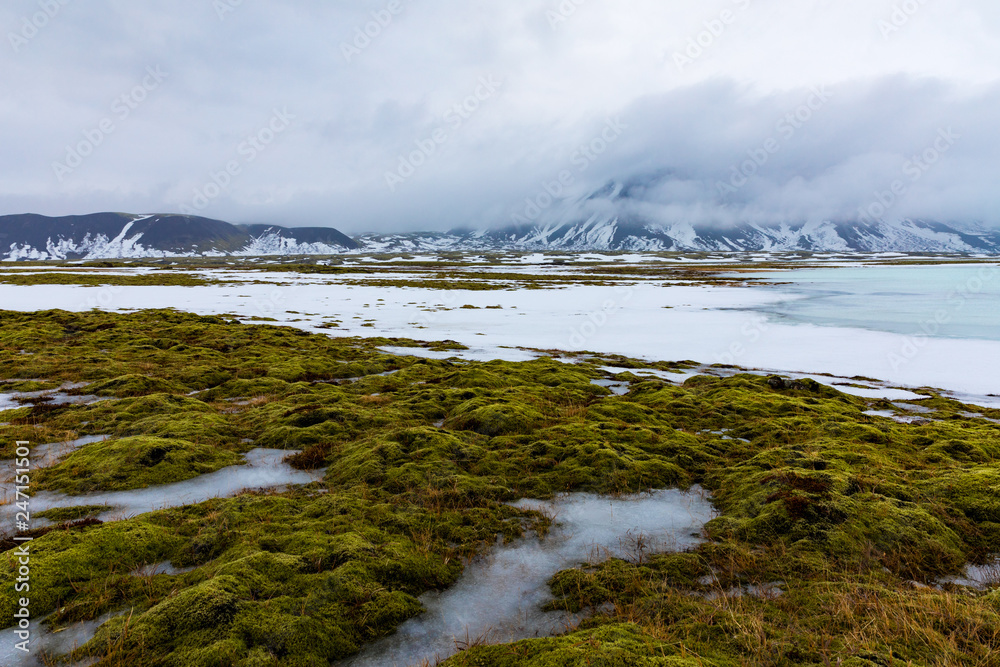 Isländische Winterlandschaft mit Bergen, See und Moos