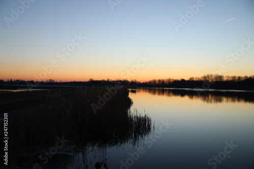 Sunset is reflecting over the water of the Rottemeren and river Rotte at Zevenhuizen close to Rotterdam in the Netherlands