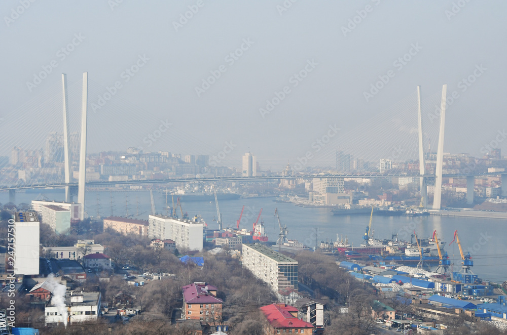 Cable-stayed bridge across the Golden horn Bay from Cape Churkin in Vladivostok in the winter in the haze