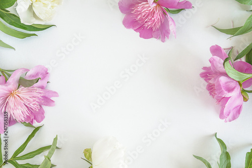 Fototapeta Naklejka Na Ścianę i Meble -  Beautiful frame of pink peonies with leaves on white backgorund