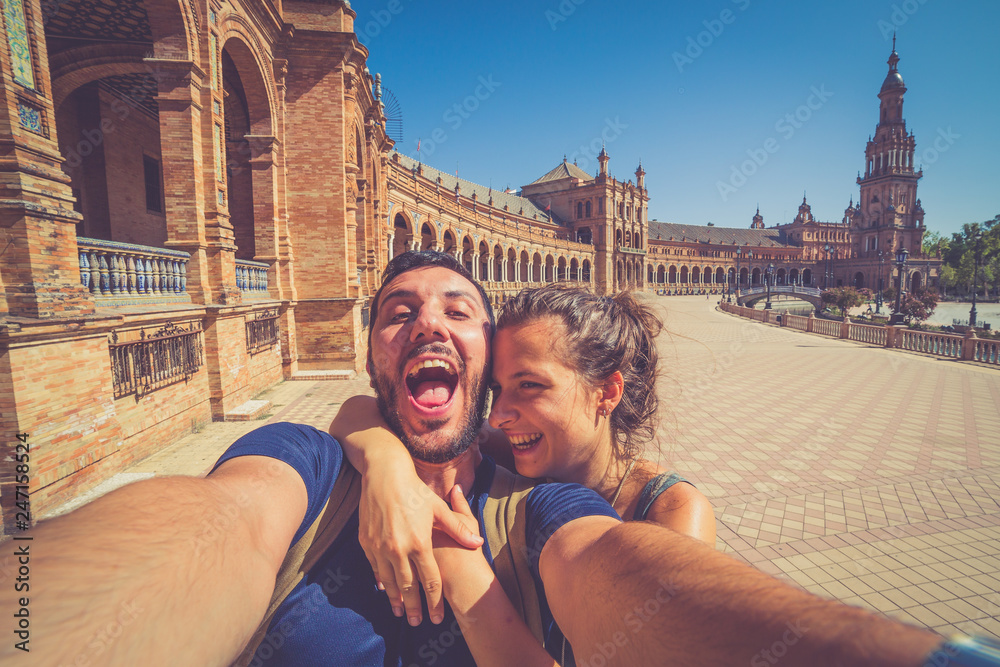 Fototapeta premium szczęśliwa uśmiechnięta para robi selfie na placu Hiszpanii (Plaza de Espana) w Sewilli w Hiszpanii