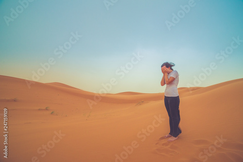 girl tourist lost in the middle of the red dunes of sahara desert  © photomaticstudio