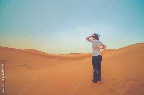 girl tourist lost in the middle of the red dunes of sahara desert 