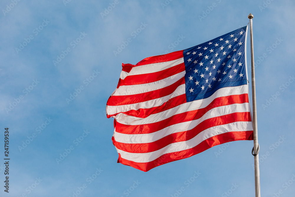 Obraz premium American flag on the blue sky with clouds