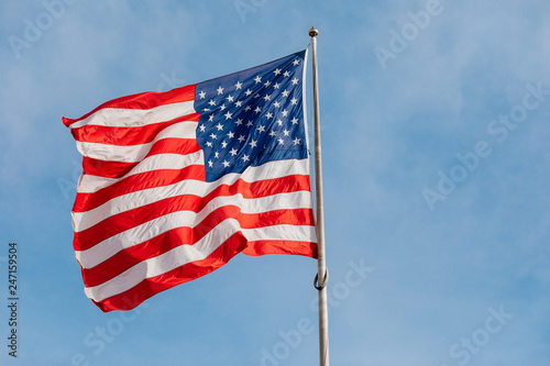 American flag on the blue sky with clouds