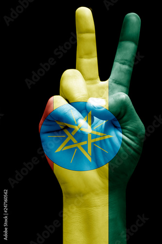 and making victory sign, Ethiopia painted with flag as symbol of victory, win, success - isolated on black background