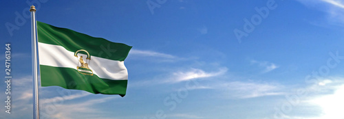 Bandera de Andalucía subida ondeando al viento con cielo de fondo photo