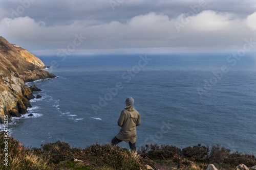 Man standing on a cliff in Howth Dublin Ireland