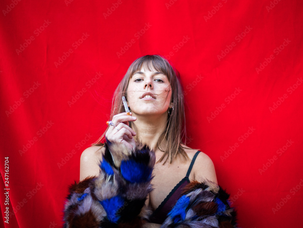 Naklejka premium woman smoking with a red background