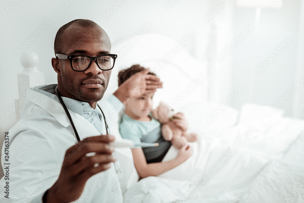 Close up of serious medical worker that checking temperature Close up of serious medical worker that checking temperature