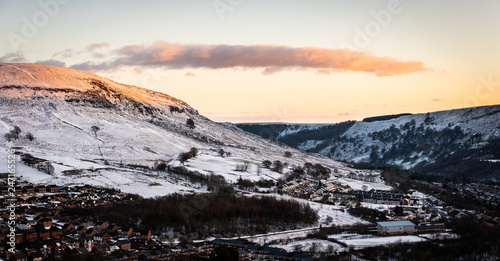 Aerial view of a small Welsh village called Nantyglo in South Wales with community and council housing covered in snow at sunset in winter
