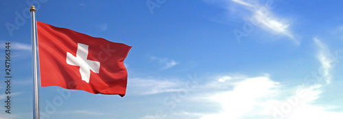 Flag of Switzerland rise waving to the wind with sky in the background photo