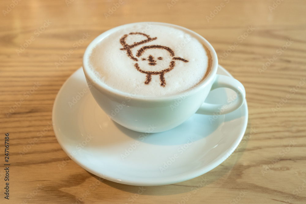 Close up a white cup of coffee with cartoon latte art made from cocoa powder Close up a white cup of coffee with cartoon latte art made from cocoa powder