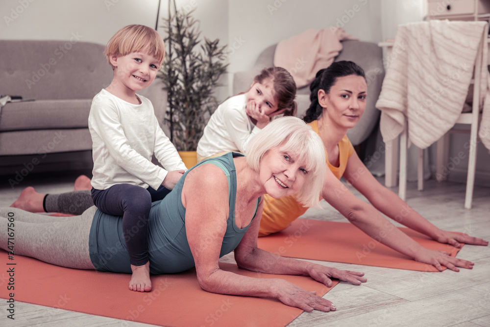 Women involving children in doing stretching exercises