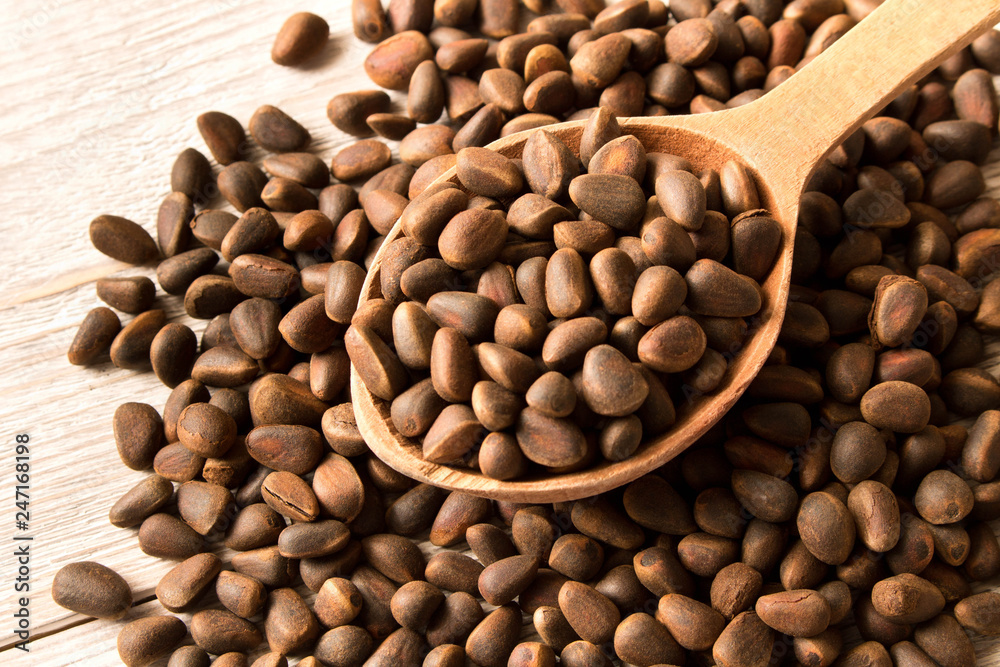 Pine nuts in a wooden spoon. Natural food. Selective focus Pine nuts in a wooden spoon. Natural food. Selective focus