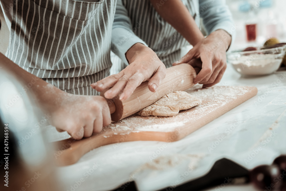 Experienced lady helping to a child to cook