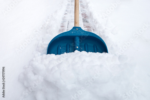 Cleaning snow with shovel in winter day