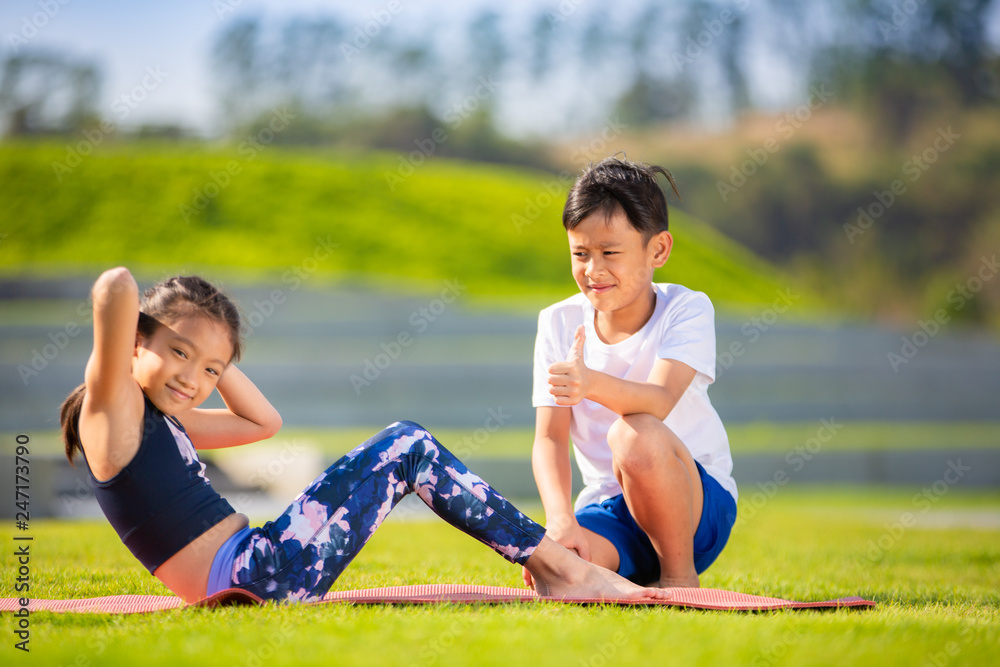 Little sporty boy and girl playing exercise or fitness outdoor, stretching muscle gymnastic Little sporty boy and girl playing exercise or fitness outdoor, stretching muscle gymnastic