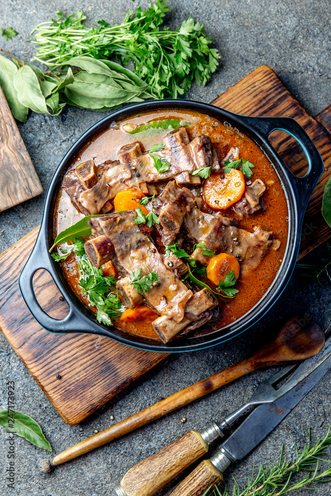 Beef ribs Bourguignon. Beef ribs stewed with carrot, onion in red wine. France dish. Top view Beef ribs Bourguignon. Beef ribs stewed with carrot, onion in red wine. France dish. Top view