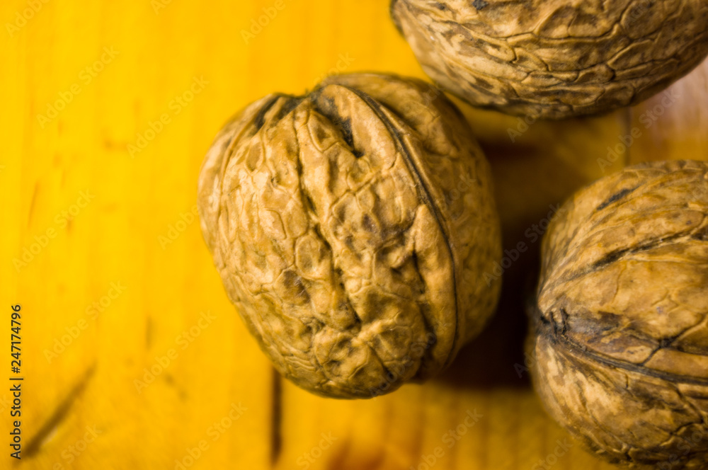 Fototapeta premium Whole walnuts on a wooden table, still life, close up