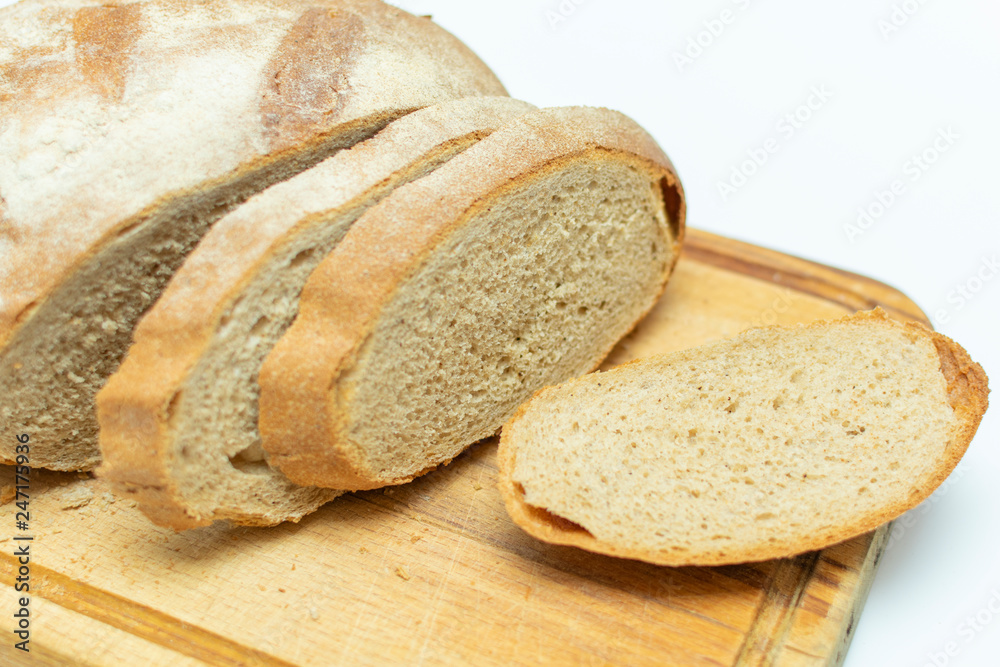 sliced fresh bread on wooden kitchen board, closeup