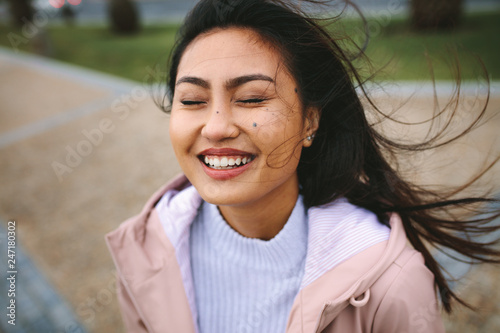 Close up of a smiling asian woman standing outdoors