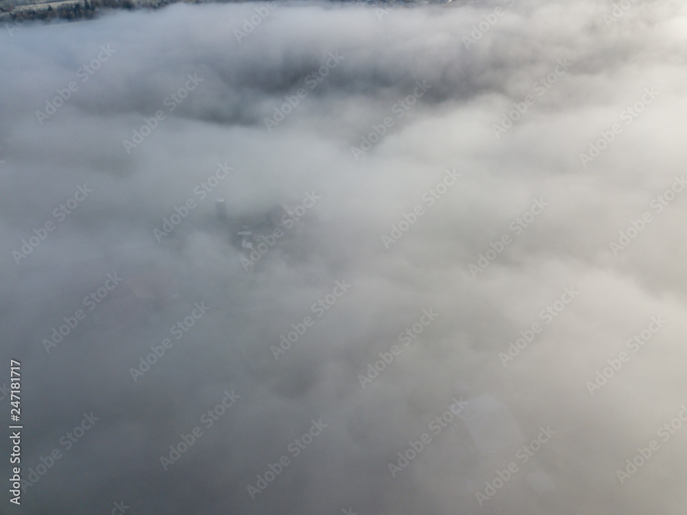 Aerial view of rural landscape in Switzerland covered with fog. Cold morning in winter with beautiful light.