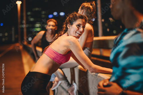 Multi-ethnic friends taking break after workout at night © Jacob Lund