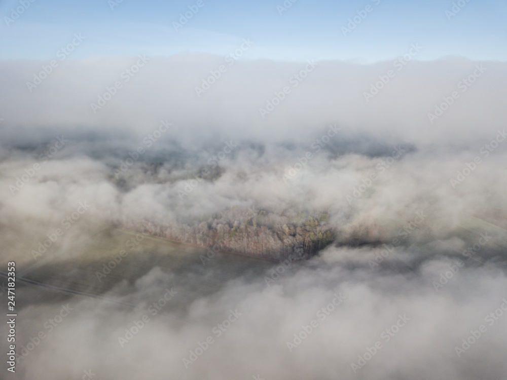 Obraz premium Aerial view of rural landscape in Switzerland covered with fog. Cold morning in winter with beautiful light.