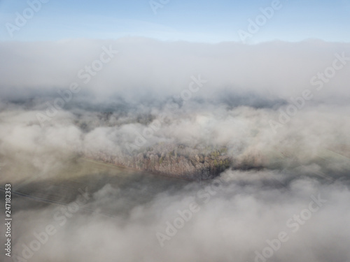 Aerial view of rural landscape in Switzerland covered with fog. Cold morning in winter with beautiful light.