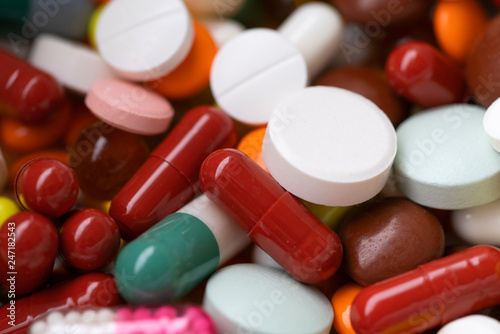 Medications, multi-colored capsules and pills, photographed close-up.