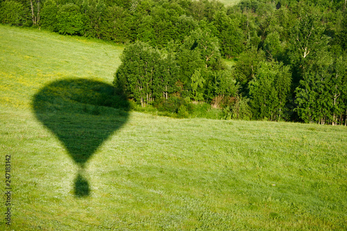 The shadow of the balloon on the background of a green meadow. photo