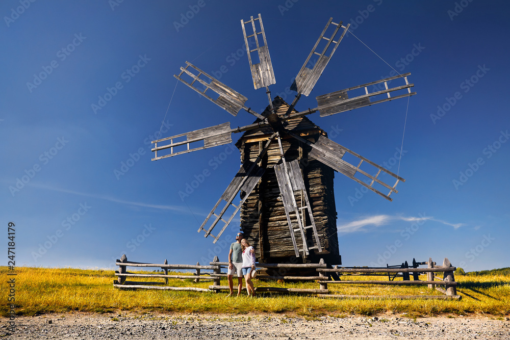 Tourist near wooden wind mill
